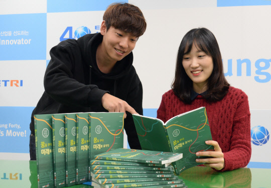 한국전자통신연구원 직원들이 연구자의 창업 이야기를 담은 책 '꿈을 꾸다 미래를 훔치다'를 소개하고 있다. ETRI 제공